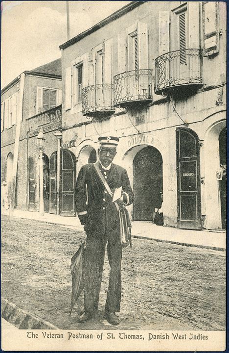 Postcard 'The Veteran Postman of St. Thomas, Danish West Indies'. He is Mr. Joseph Lorand, the longest serving postal service worker in the Danish West Indies and was honored and received the silver cross of Dannebrogsmand. 